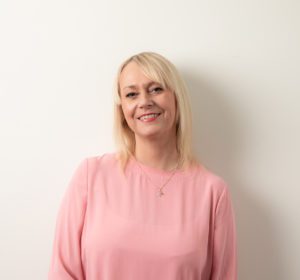 blonde woman with a light pink blouse on