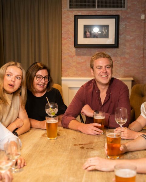 group of people sitting around a table drinking